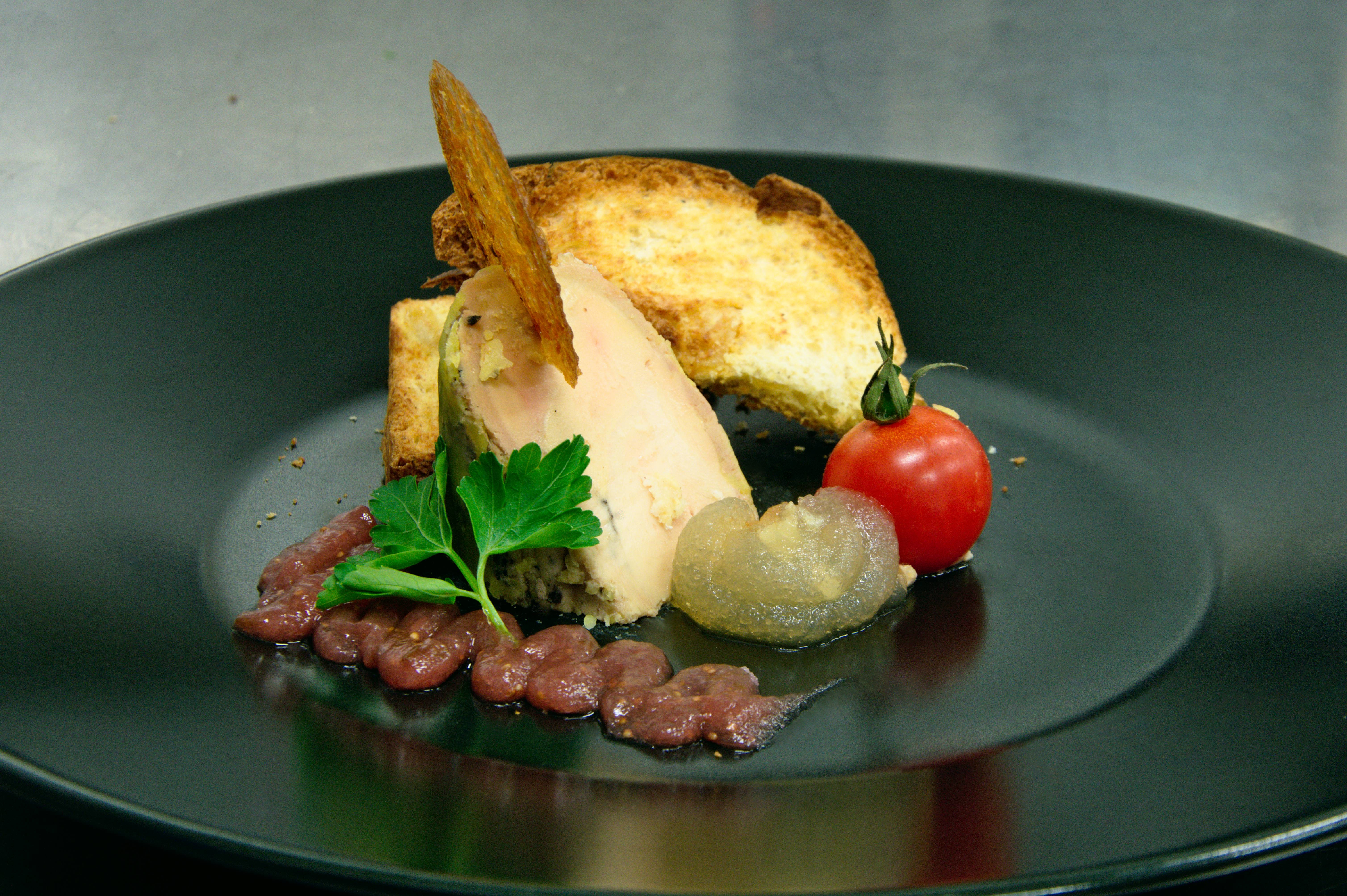Médaillon de foie gras mariné à l'huile de noisette et truffe, duo de gelée de figue et pomme verte, brioches aux épices et aux raisins